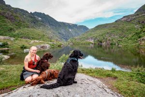 Anna and three dogs next to a lake in Lofoten Islands